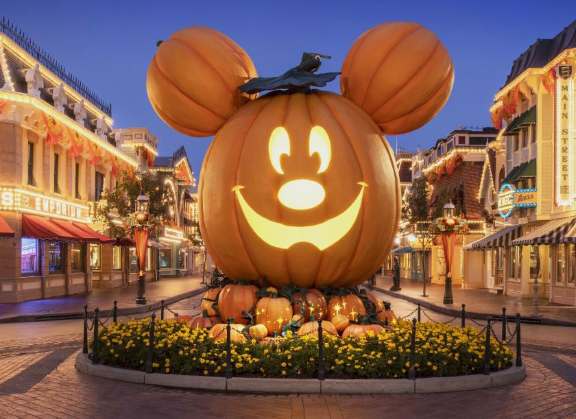 Mickey mouse jack-o-lantern with lighted buildings on Main St.